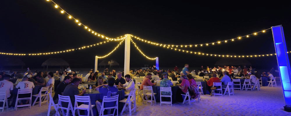 group of incentive trip attendees having diner on the beach