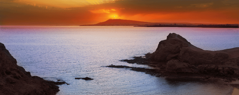 overview of the beach with rocks and a sunset