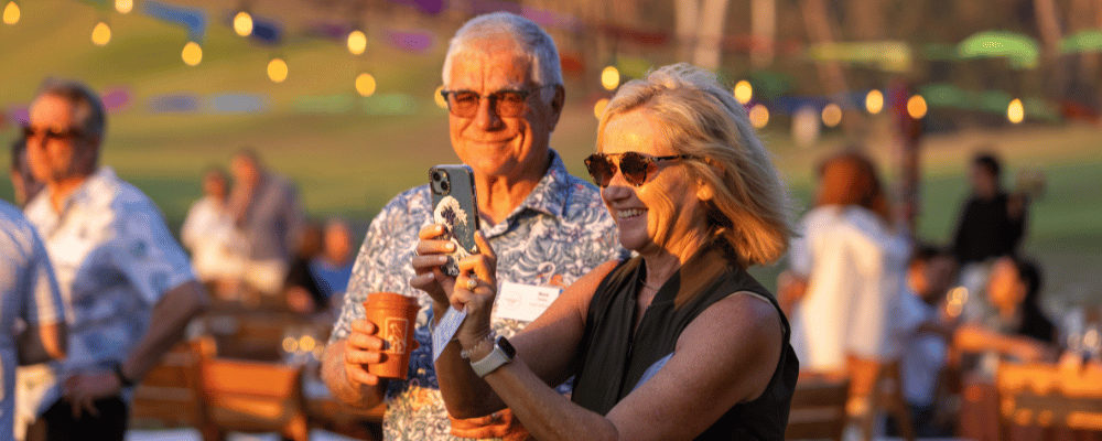 group of incentive trip attendees taking photos during an event