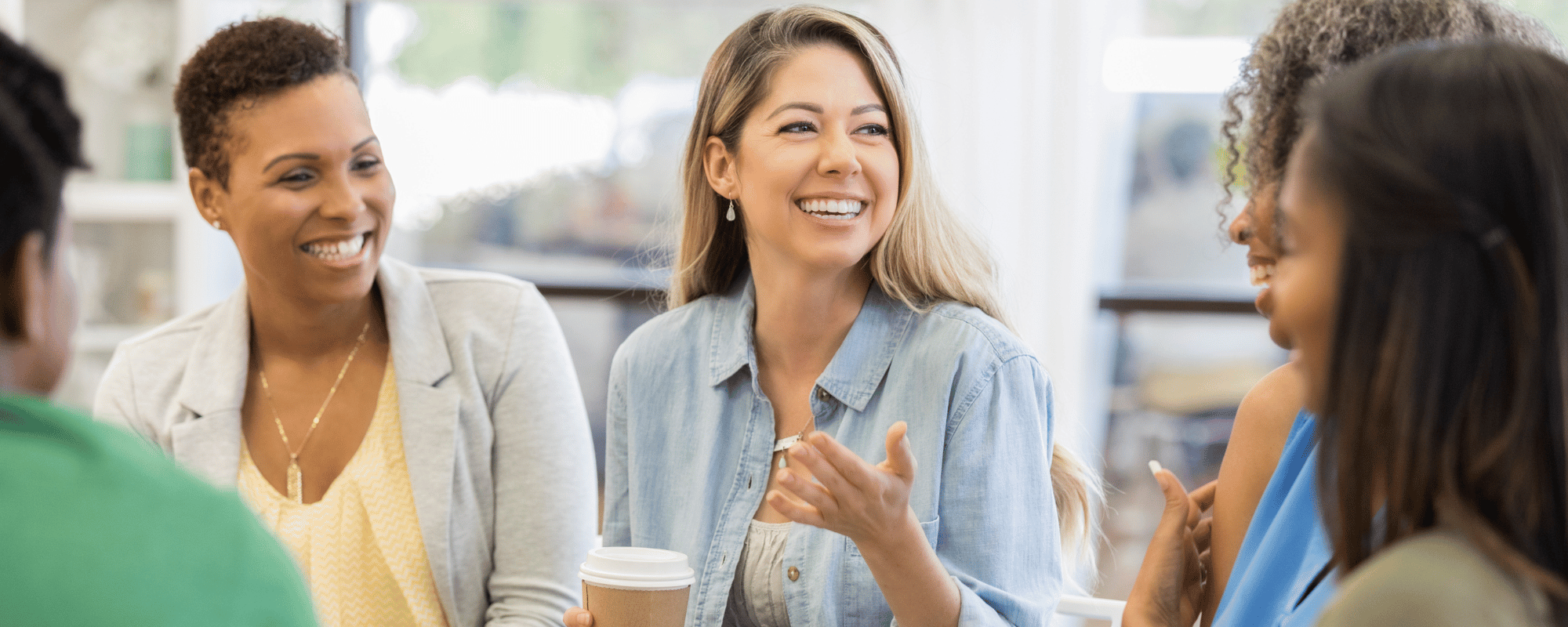 group of women happily discuss a topic related to their sales kickoff theme