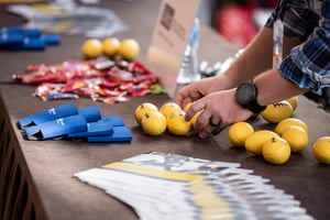 person placing event branding giveaways on table at a conference