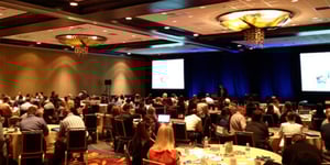 group of attendees watching a presentation at a roadshow event