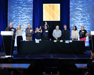 Company members on stage celebrating winning a game 