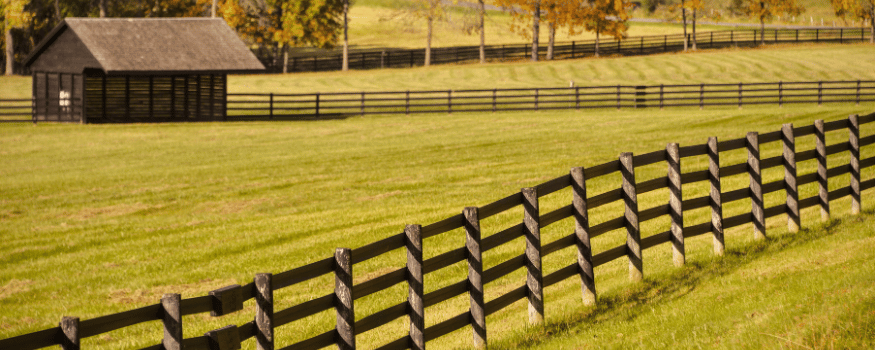 wyoming field with a barn and fence