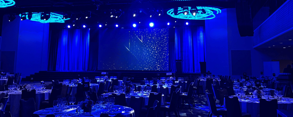 main conference stage with blue lights and tables